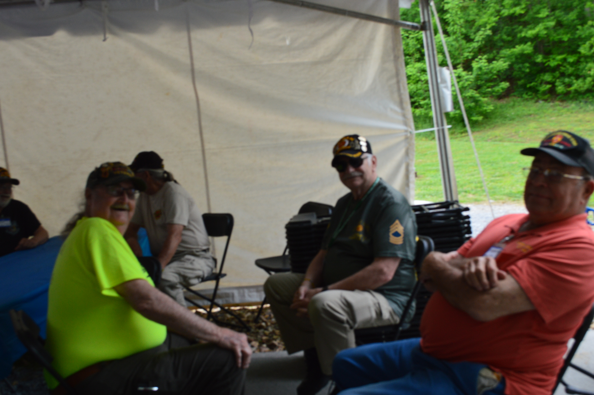 Veterans relaxing together under the reunion tent